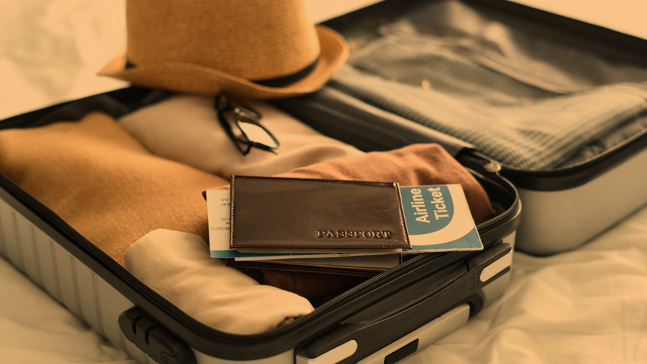 fotografia ilustrativa de uma mala de viagem e passaporte - Contratar uma agência de viagens vale a pena? 